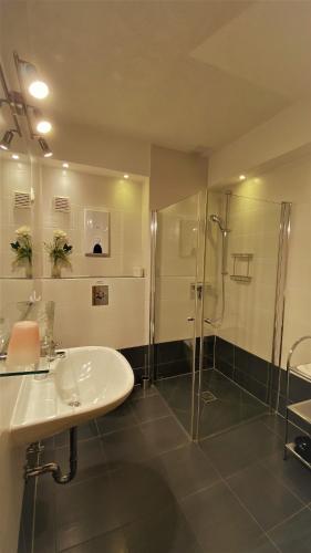 a bathroom with a sink and a shower at Pension Body Sun in Niesky
