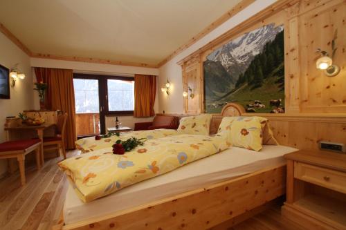 a bedroom with a large bed in a room at Hotel Humlerhof in Gries am Brenner