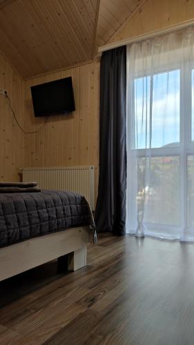 a bedroom with a bed and a large window at Приватна садиба Соломія in Bukovel
