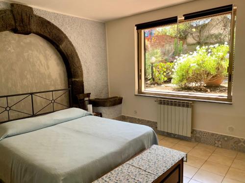 een slaapkamer met een bed en een raam bij La casa nel bosco in Trecastagni