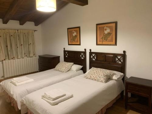 a bedroom with two beds with towels on them at Casa Clemente II in La Hiruela