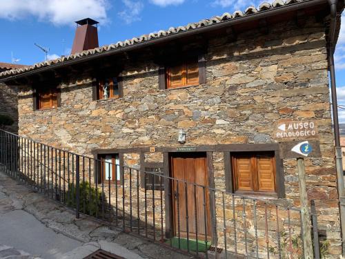 a stone building with a fence in front of it at Casa Clemente II in La Hiruela