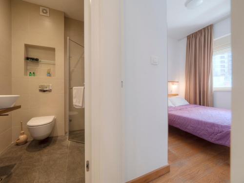 a bathroom with a bed and a toilet and a sink at Seaside Rest Apartments in Budva