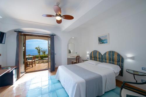 Maresca Hotel Praiano في برايانو: غرفة نوم مع سرير وإطلالة على المحيط