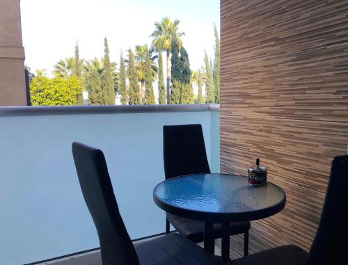 une table et des chaises assises sur une terrasse avec un mur dans l'établissement Seafront - 2 bedroom Modern, à Limassol