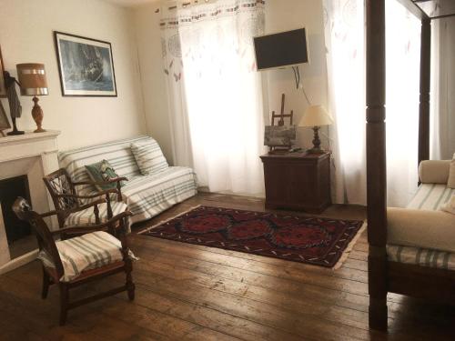sala de estar con sofá y silla en GÎte indépendant dans une villa -Vue et accès direct mer - avec 3 chambres et 3 grandes terrasses, en Perros-Guirec