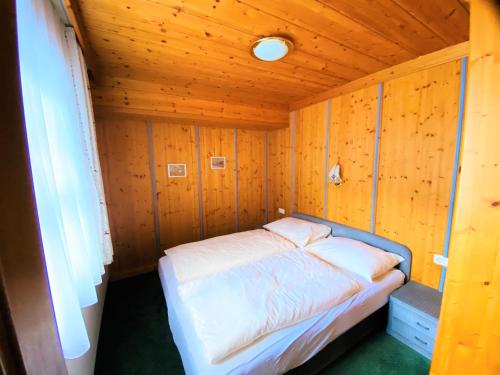 a small bedroom with a bed in a wooden room at Haus Wagrain in Wagrain