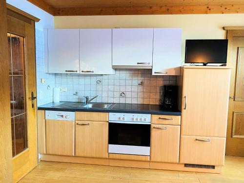 a kitchen with white cabinets and a sink at Haus Wagrain in Wagrain