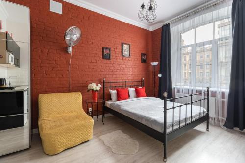 a bedroom with a bed and a red brick wall at Апартаменты "Джулиата" на Невском in Saint Petersburg