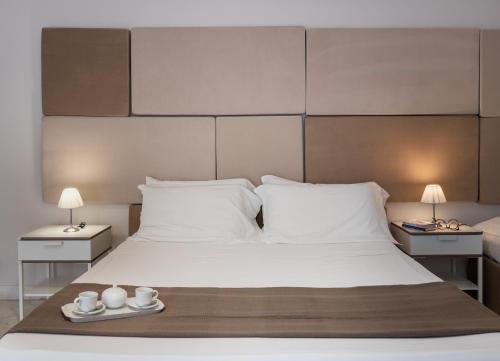 a bedroom with a large white bed with two tables at Nonna Nina in Avola