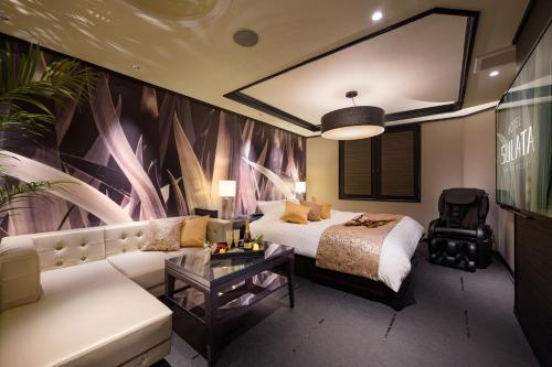 a hotel room with a bed and a couch at HOTEL SULATA GIFU HASHIMA (Adult Only) in Hashima