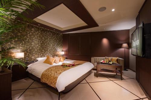 a bedroom with a large bed and a table at HOTEL SULATA GIFU HASHIMA (Adult Only) in Hashima
