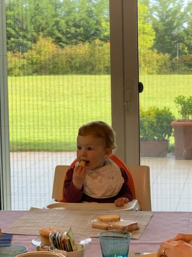 a baby sitting in a high chair eating food at B&B Beauty House in Cesena