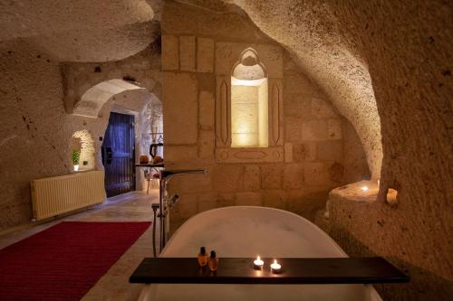 a bathroom with a bath tub in a stone building at Sato Cave Hotel in Göreme