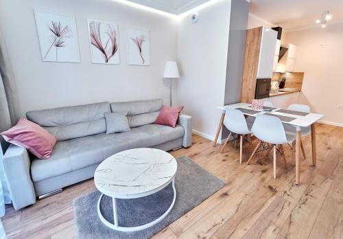 a living room with a couch and a table at LAGUNA Apartament Polanica Residence 28 in Polanica-Zdrój