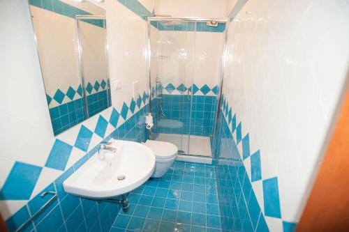 een blauw betegelde badkamer met een wastafel en een toilet bij Cetara House 1 on Amalfi coast - Happy Rentals in Cetara