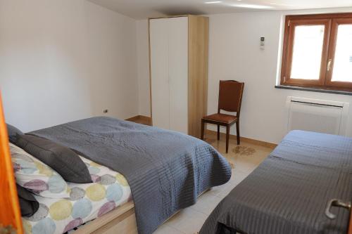 een slaapkamer met een bed, een stoel en een raam bij Cetara House 1 on Amalfi coast - Happy Rentals in Cetara