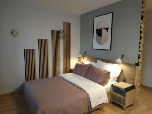 a bedroom with a large bed with a night stand at apartament Forest Karpacz in Karpacz