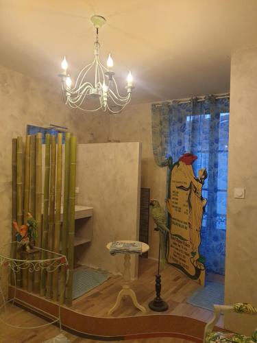 une chambre avec un lustre, une chaise et des livres dans l'établissement la maison porte bonheur, à Chantelle