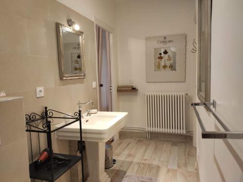 a white bathroom with a sink and a mirror at Chambres d'Hôtes de luxe Côté Parc-Côté Jardin avec parking privé gratuit in Nevers