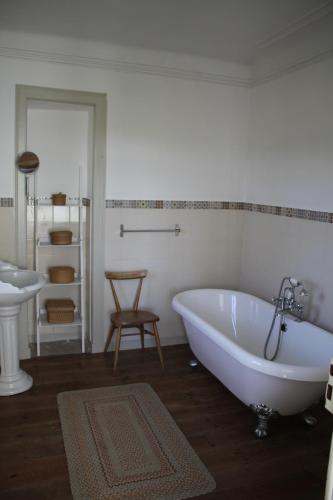a white bathroom with a tub and a sink at The Little Olive Quinta in Alvaiázere