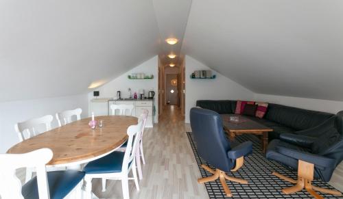a living room with a table and a couch at The Boathouse in Streymnes