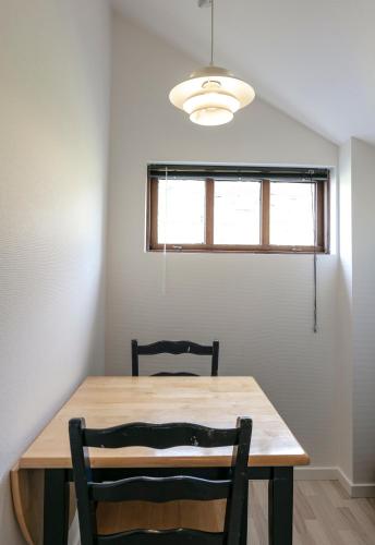 a dining room table with two chairs and a window at The Boathouse in Streymnes