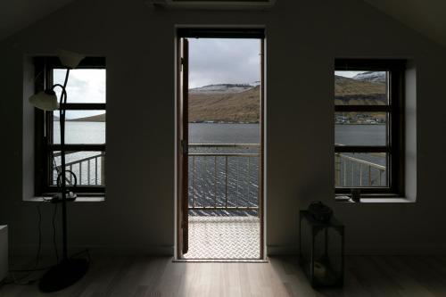 an open door to a room with a view of the water at The Boathouse in Streymnes
