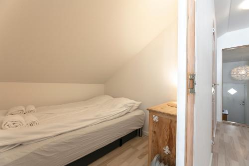 a small bedroom with a bed and a mirror at The Boathouse in Streymnes