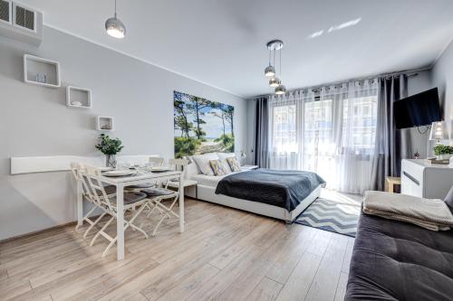 a living room with a bed and a table at Apartamenty Na Zdrojowej - visitopl in Świnoujście