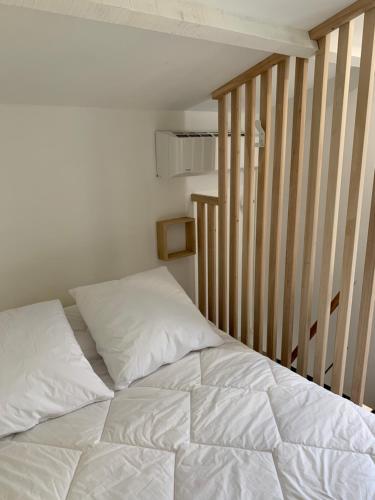 - un lit blanc dans une chambre avec un escalier dans l'établissement Maison de la Mer, à Port-Leucate