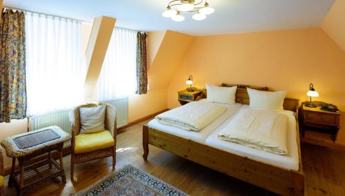 a bedroom with a large bed and a chair at Hotel Theophano in Quedlinburg