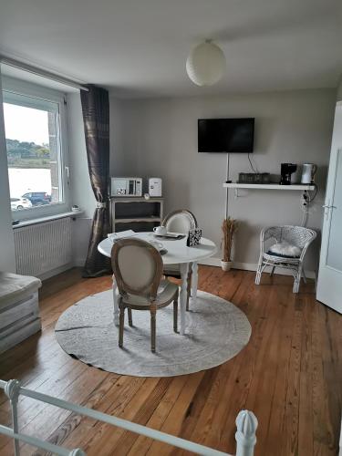 un salon avec une table et des chaises dans l'établissement Chambres d'Hôtes vue mer entre Plestin les Grèves et locquirec, à Plestin-les-Grèves