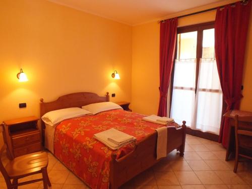 a bedroom with a large bed and a window at Enolocanda Del Tufo in Dogliani