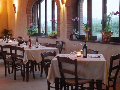 una sala da pranzo con tavoli, sedie e finestre di Enolocanda Del Tufo a Dogliani
