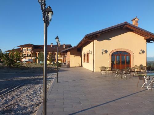 a building with tables and chairs in front of it at Enolocanda Del Tufo in Dogliani