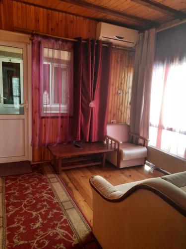 a living room with a couch and a table and window at Kitech Guest House in Odesa