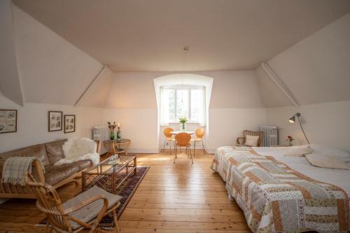 a attic bedroom with two beds and a couch at Inspiration Center Denmark, Guesthouse in Maribo