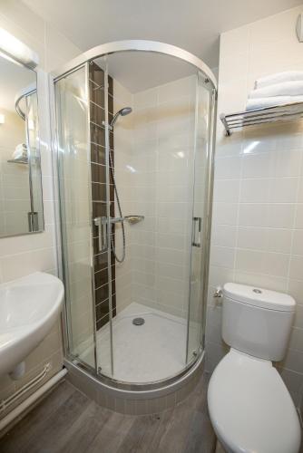 a bathroom with a shower and a toilet and a sink at Tulip Inn Beaune in Beaune