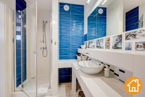 a bathroom with a glass shower and a sink at Apartamenty Horyzont - visitopl in Międzyzdroje