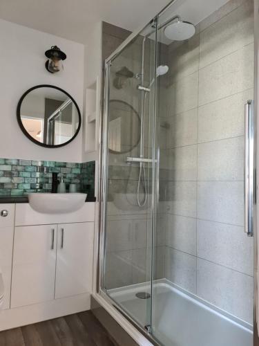 a bathroom with a glass shower and a sink at EDEN Apartment, Oban in Oban