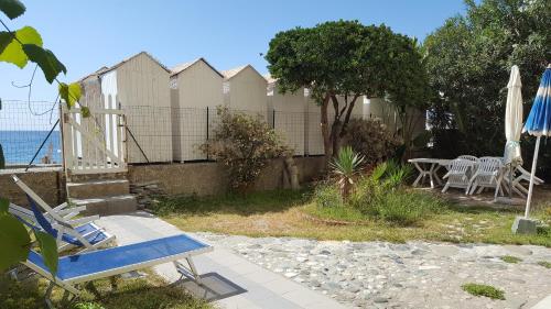 瓦拉澤的住宿－CASAVACANZE GIEFFE，院子里的蓝色椅子和雨伞