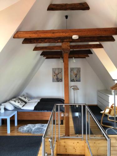 een slaapkamer met een bed in een loft met houten balken bij "Eiche" in Ilsenburg