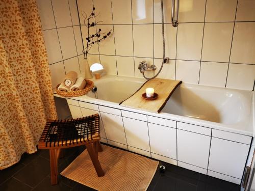 La salle de bains est pourvue d'une baignoire, d'une table et d'une chaise. dans l'établissement "Eiche", à Ilsenburg