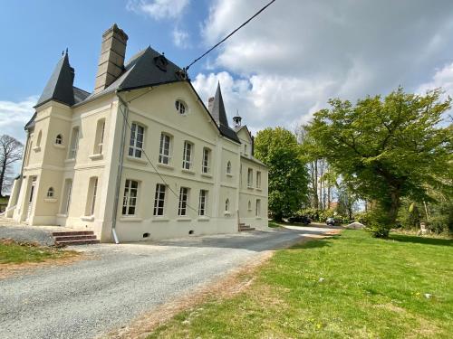 a large white building with a tower on top at Manoir de L'Oiselière in La Remuée