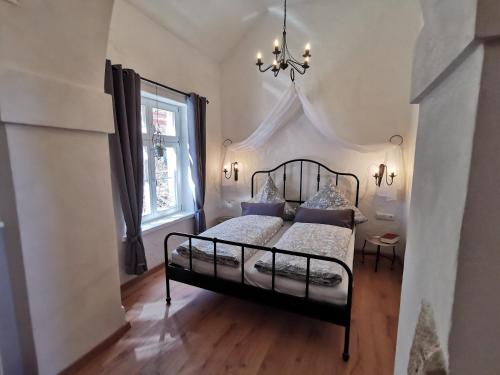 a bedroom with a black bed and a window at Gästehaus Vergissmeinnicht in Guteborn