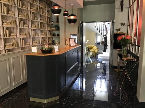 a lobby with a counter and shelves of books at Le Grand Hôtel Mont Dore in Le Mont-Dore