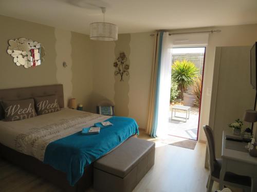 a bedroom with a bed and a door to a patio at Chambres d'Hotes La Maison Neuve in Saint-Loup