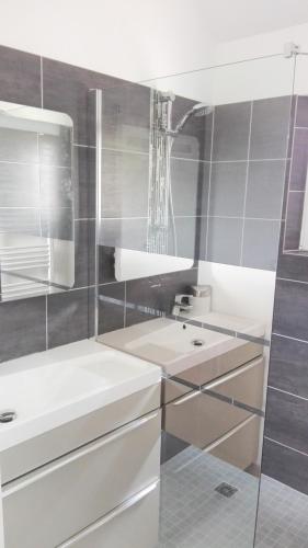 une salle de bain blanche avec un lavabo et un miroir dans l'établissement Gîte du Moulin, à Mosles