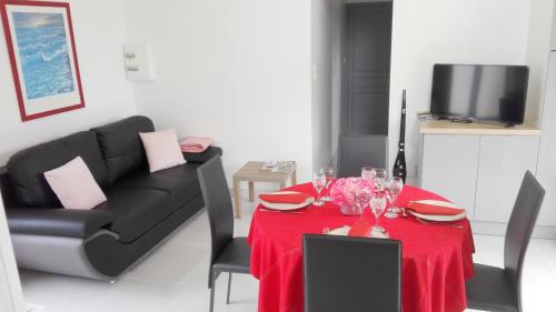 - un salon avec une table rouge et un canapé dans l'établissement Gîte du Moulin, à Mosles